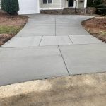 Our Work: A concrete driveway in front of a house.