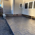 Our Work: A stamped concrete patio in a backyard.