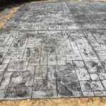 Our Work: A concrete patio with a black and white design on it.