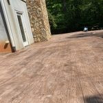 Our work includes designing and building a concrete patio in a wooded area, creating a beautiful and functional outdoor space.