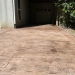 Our Work: A concrete driveway with a wooden walkway.