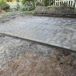 Our Work includes the construction of a concrete patio in a backyard.