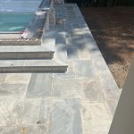 Our Work: A stone patio with a pool and steps.