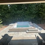 Our Work: Transformed a backyard into a stunning oasis featuring a pool complete with table and chairs for ultimate relaxation.