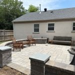 Our Work: A backyard patio with a fireplace and seating area.