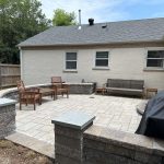 Our Work: A backyard patio with a grill and patio furniture.