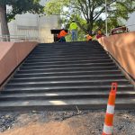 Our Work: A group of construction workers are working on a set of stairs.