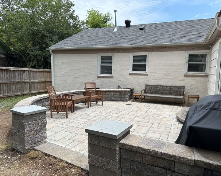 A city backyard patio with a grill and seating area, featuring concrete walls for added style and ambiance.