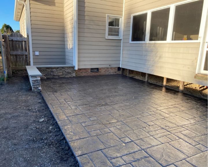 A stamped concrete patio installed by experienced Concrete Contractors in Cary, NC, elegantly enhances the backyard.