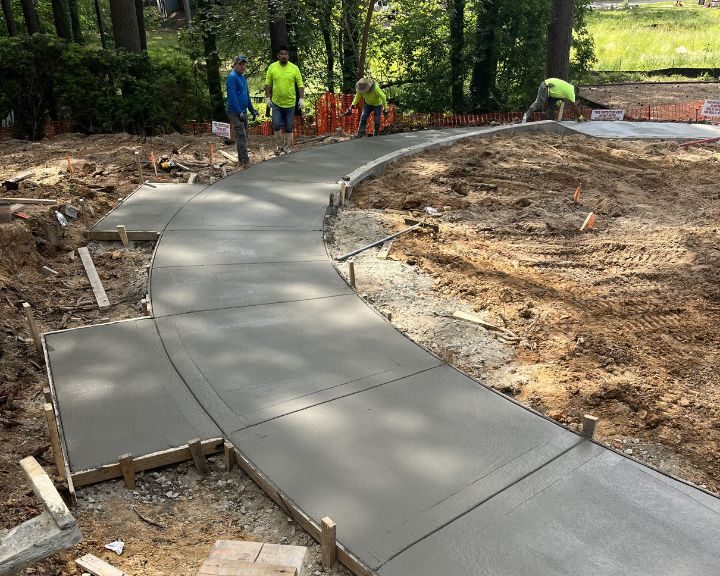 A concrete walkway being built in a city park.